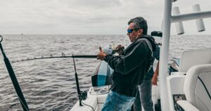 Fishing charter Captain Herman Dorado reeling in a catch.