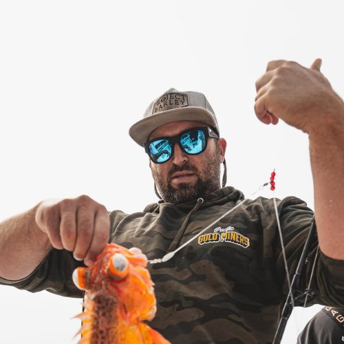 Man handling fish caught on fishing charter.
